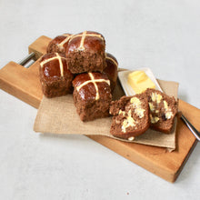 Load image into Gallery viewer, Gluten Free hot cross buns on wooden board with butter in white dish. One bun cut in half spread with butter 